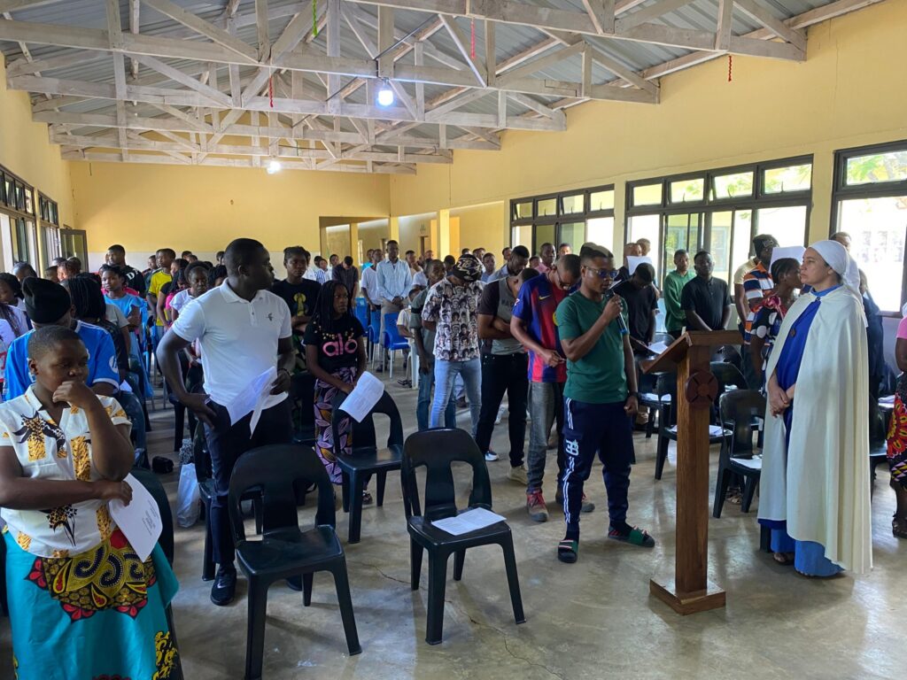 Participantes reunidos no salão durante o Festival de Jovens em Dombe.