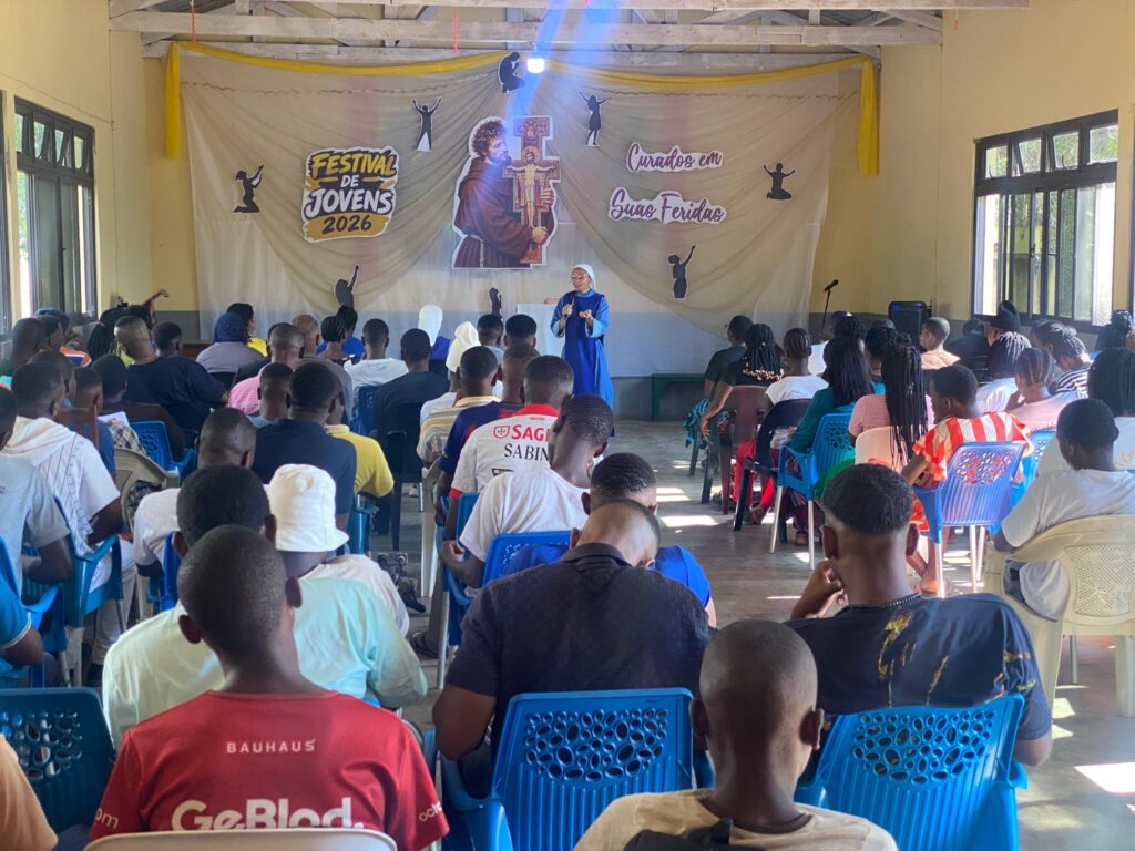 Participantes acompanham a programação diante do painel “Curados em Suas Feridas”.
